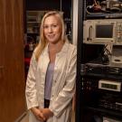Stacey standing next to electrophysiology rig